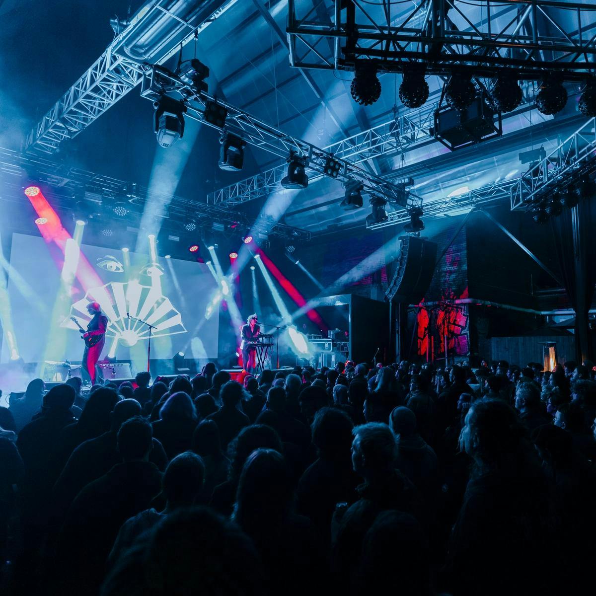 2 people on stage with a crowd watching them