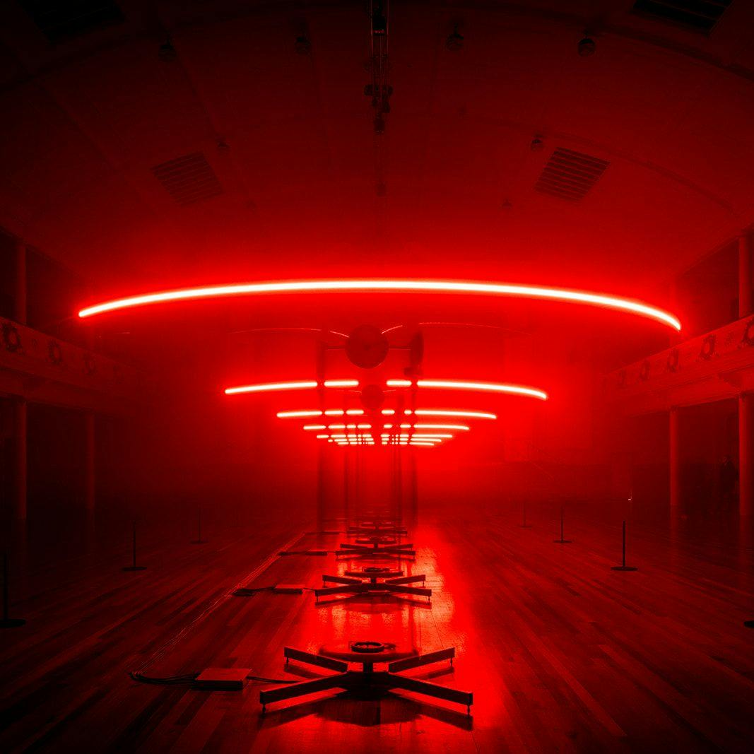 Red light hanging horizontally over an art installation