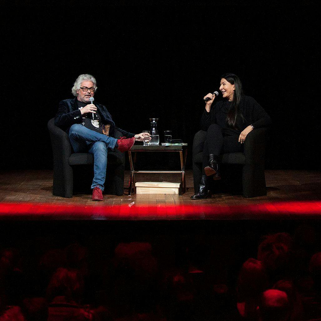 Marina Abramovic and David Walsh sit on-stage talking to eachother.